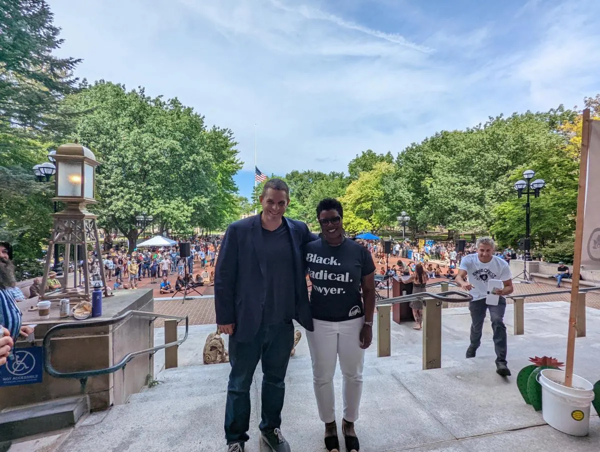 A large crowd fills the Diag, two speakers for Entheofest pose for a photo in front of the crowd.